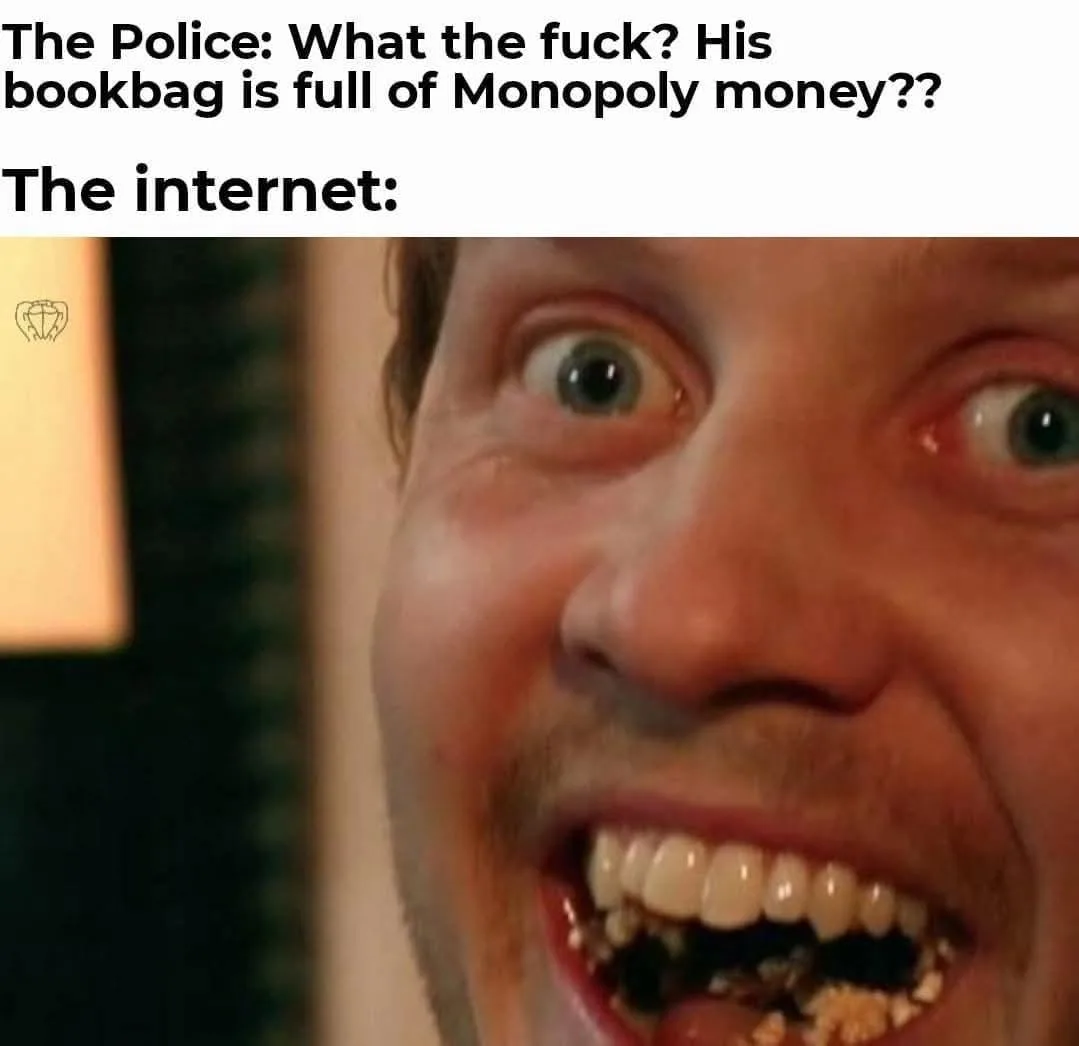 A close-up image of a man with wide, shocked eyes and a wide, toothy grin, his mouth filled with what appears to be dark…