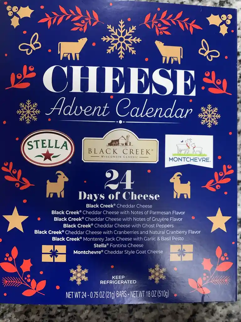 A blue cheese advent calendar box decorated with red and gold holiday motifs like snowflakes, holly, and goats. It features…