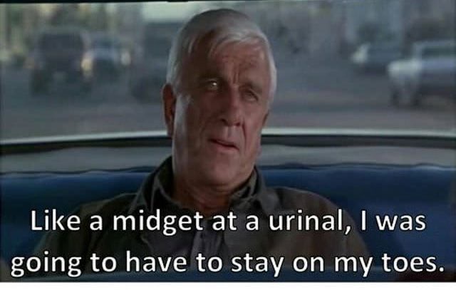 A still from a movie shows an older man with gray hair sitting in the back of a car, looking concerned. White text overlaid…
