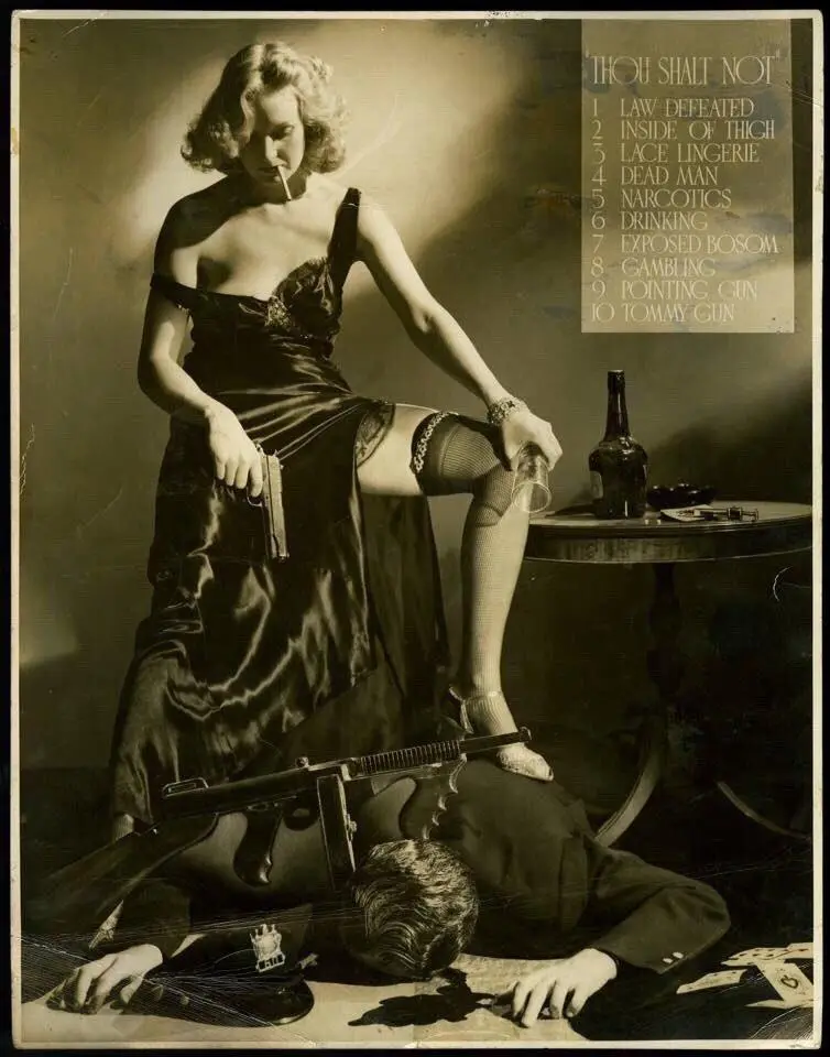 A vintage black-and-white photo shows a woman in a satin dress and stockings, smoking a cigarette and holding a pistol…