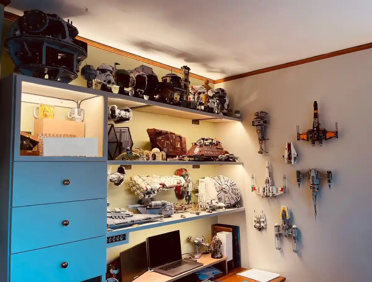 A room filled with extensive Lego Star Wars collections, including a large Death Star model on top of a blue cabinet…