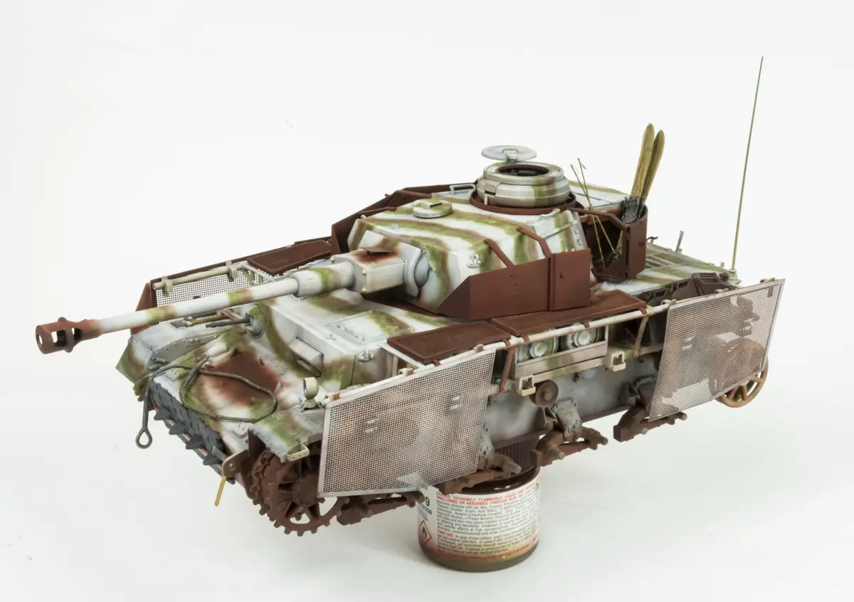 a highly detailed scale model of a military tank with camouflage paint, mounted on a can of hairspray labeled with chemical…