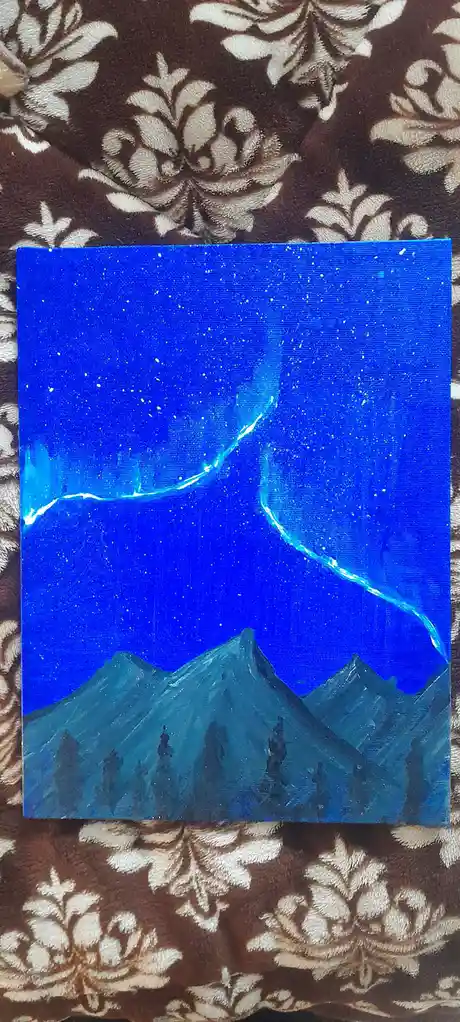A hand-painted canvas depicts a starry blue night sky with glowing aurora borealis arches over dark mountain silhouettes…