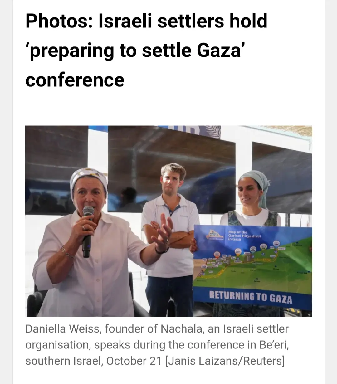 A woman in a white shirt and headscarf speaks into a microphone while two others stand beside her; one holds a map titled…