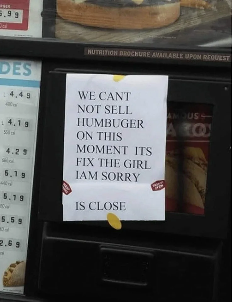A handwritten note taped to a fast-food menu display reads 'WE CANT NOT SELL HUMBUGER ON THIS MOMENT ITS FIX THE GIRL I AM…