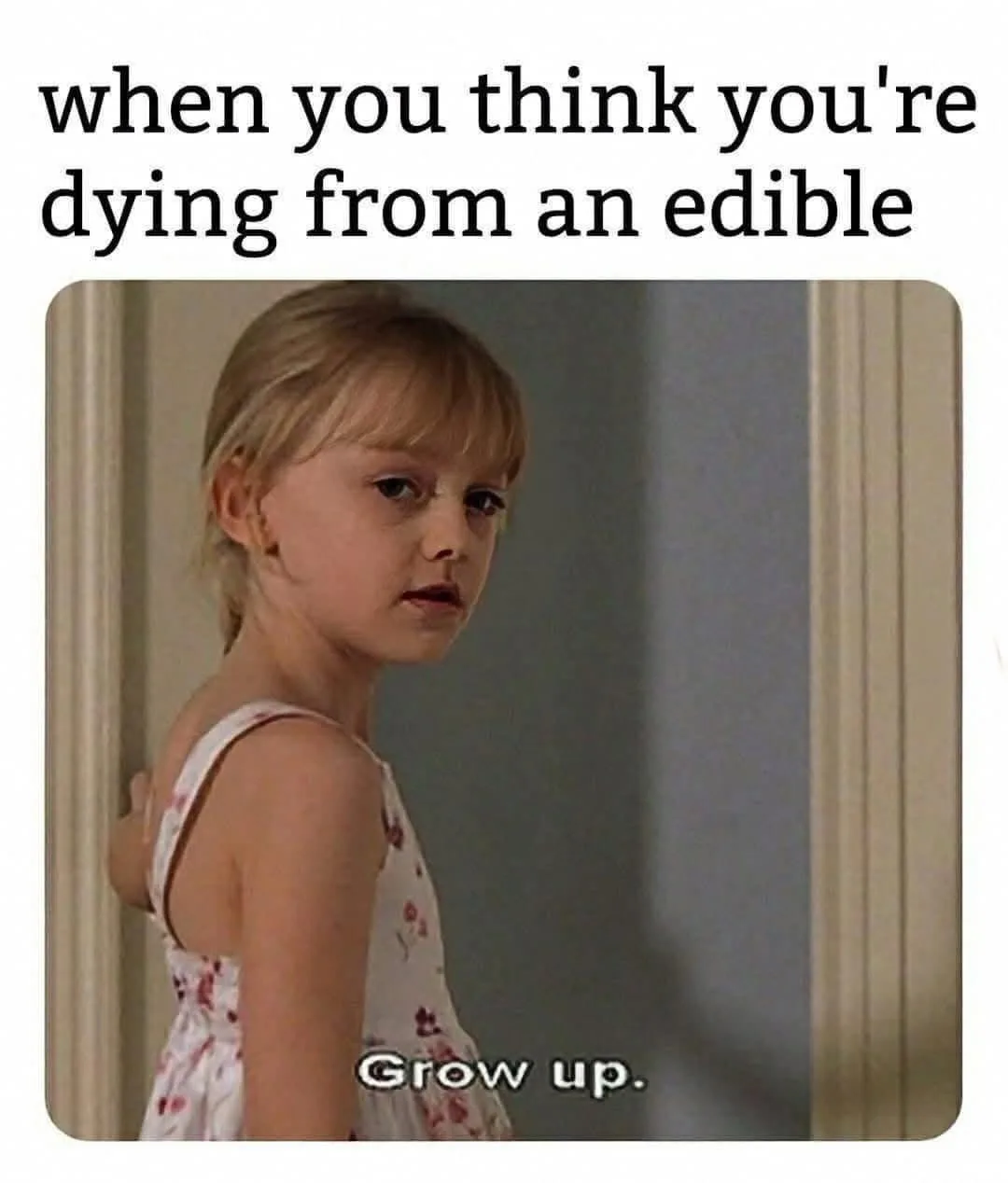 A young girl with blonde hair in a floral dress stands in a doorway, looking over her shoulder with a deadpan, exasperated…