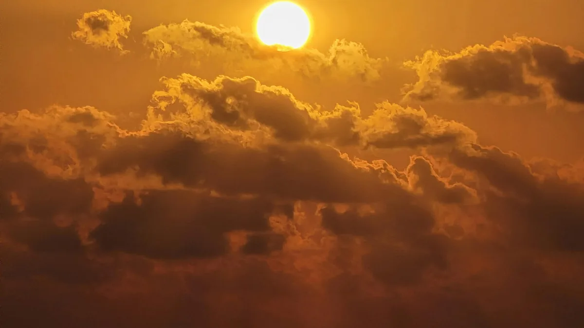 Vibrant golden hues illuminate the horizon as the day succumbs to the ocean's crimson kiss. Dramatic clouds, tinted with…