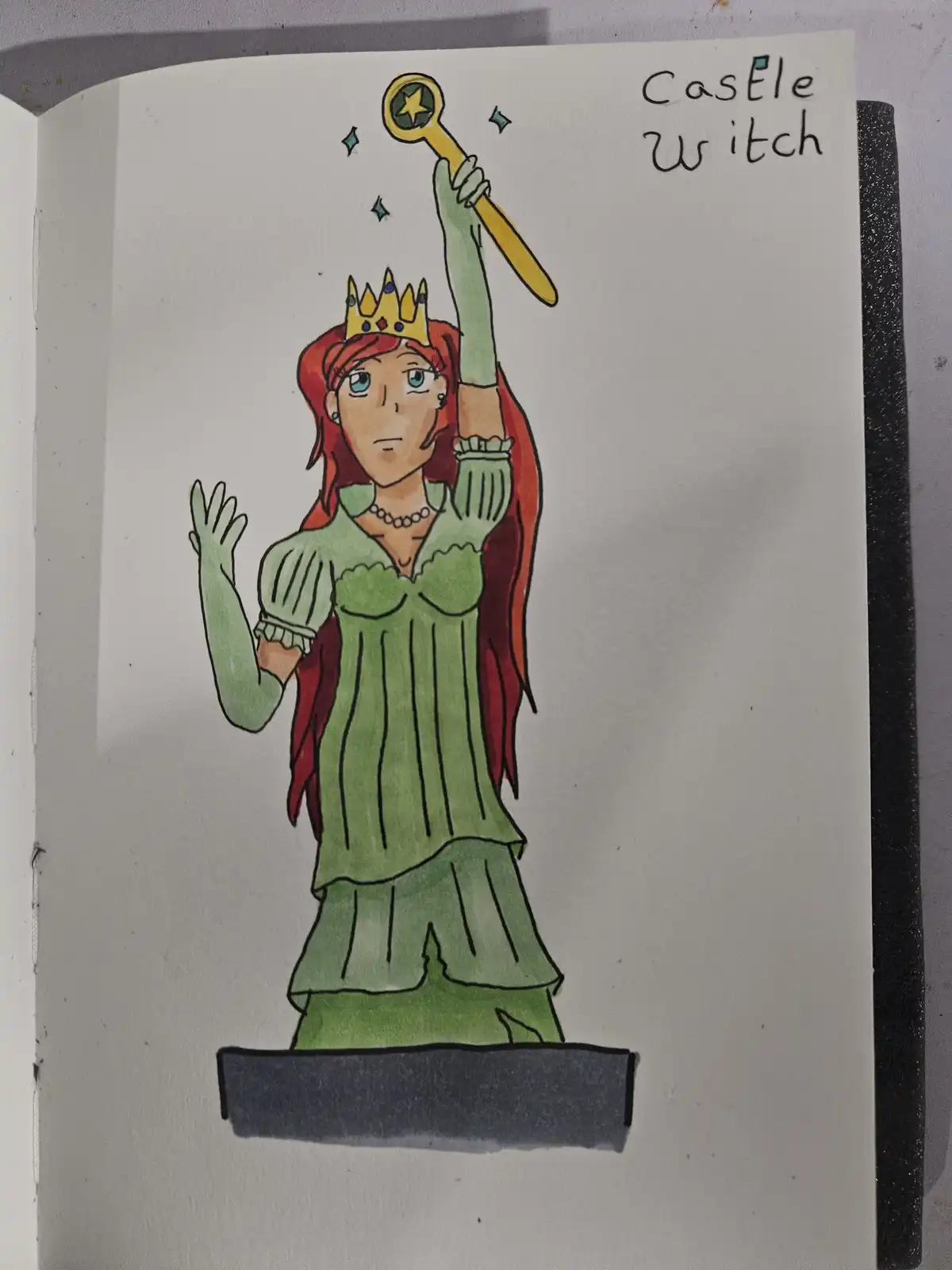 A hand-drawn illustration in a notebook shows a woman with red hair and a gold crown, wearing a green dress and standing on…