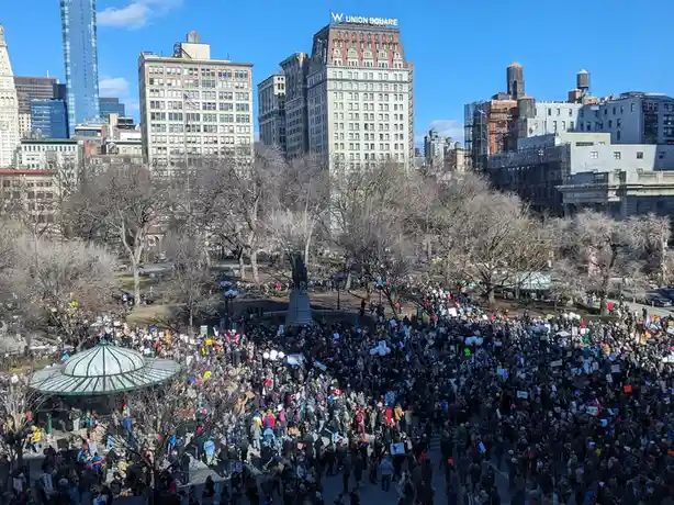 A wide-angle photo shows a massive crowd of protesters filling Union Square in New York City, holding signs and banners…