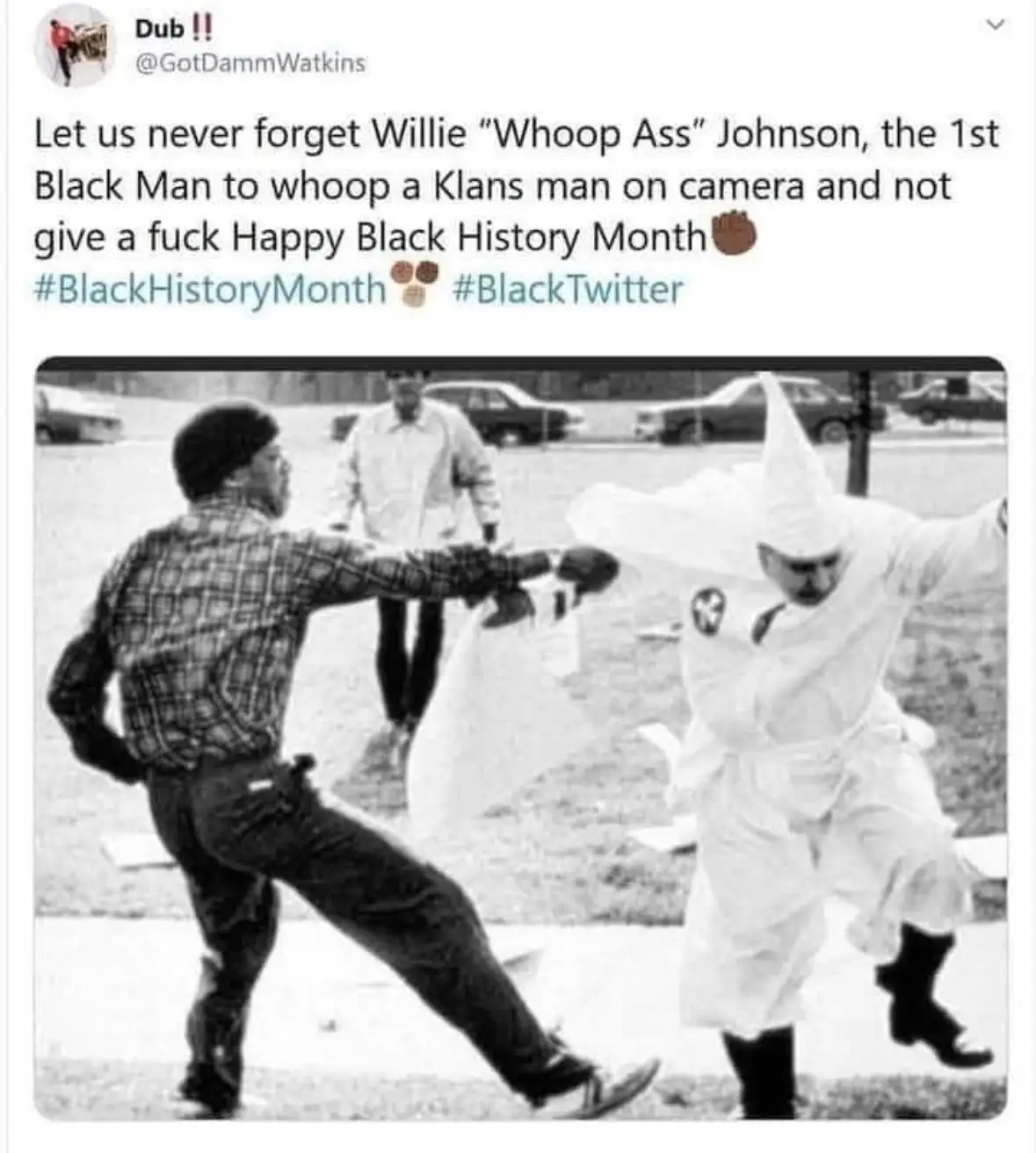 A black-and-white photo shows a Black man in a plaid shirt punching a white man in a Ku Klux Klan robe and hood. A third…