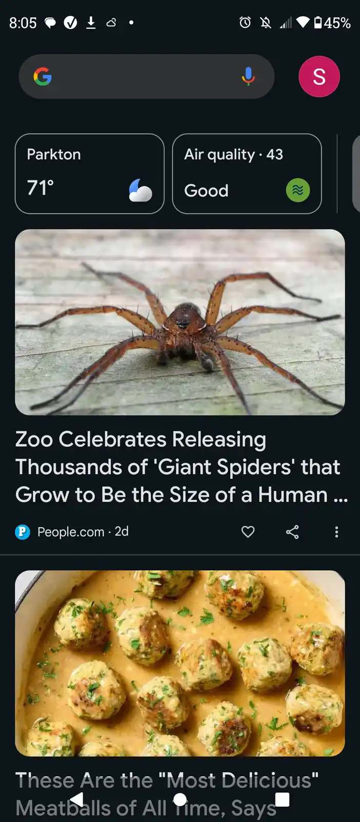 A smartphone screen shows a news feed with a photo of a large brown spider above a headline about 'giant spiders' being…