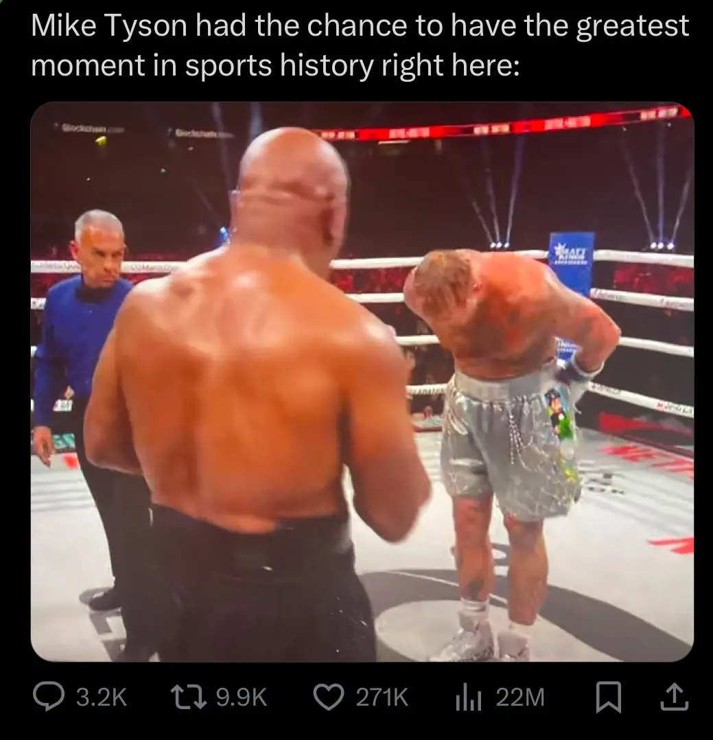 A still from a boxing match shows Mike Tyson, seen from behind, standing over a heavily bruised and bloodied opponent who is…