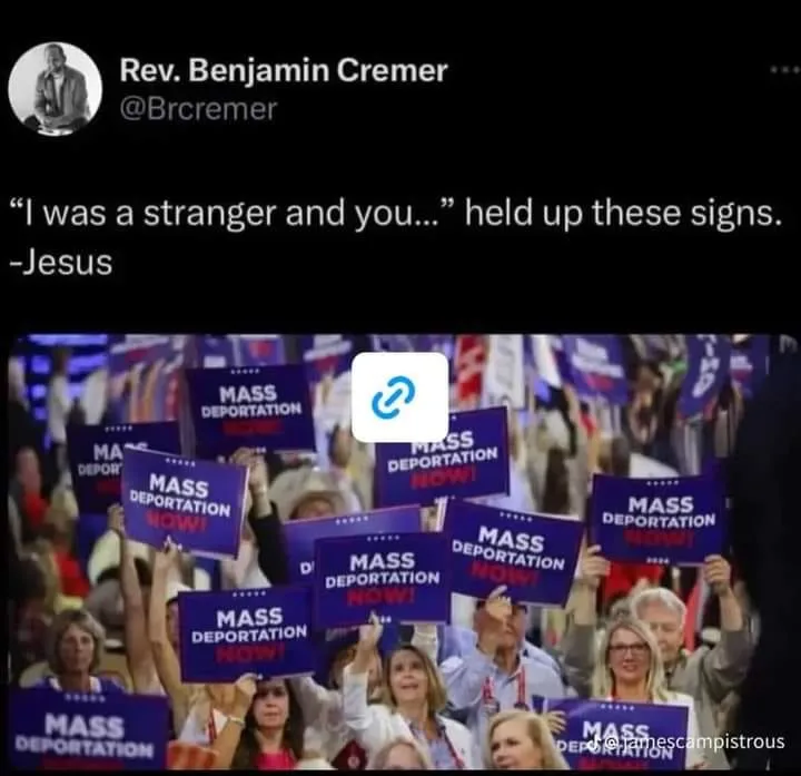 A crowd of people at a political rally holds up numerous blue signs that read 'MASS DEPORTATION NOW!' in bold white and red…
