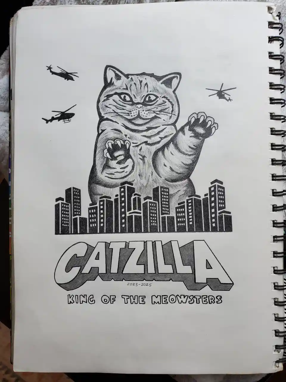 A hand-drawn black-and-white illustration on a spiral-bound notebook page depicts a giant, menacing cat standing over a city…