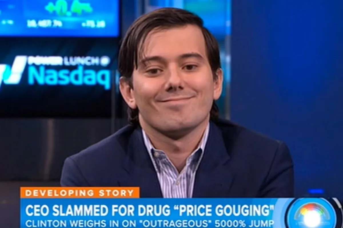 A man in a suit smiles smugly on a news set with 'POWER LUNCH @ Nasdaq' visible behind him. A news ticker at the bottom…