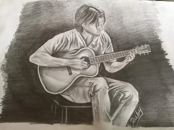 A pencil sketch depicts a man sitting on a stool, playing an acoustic guitar with focused expression. The background is dark…
