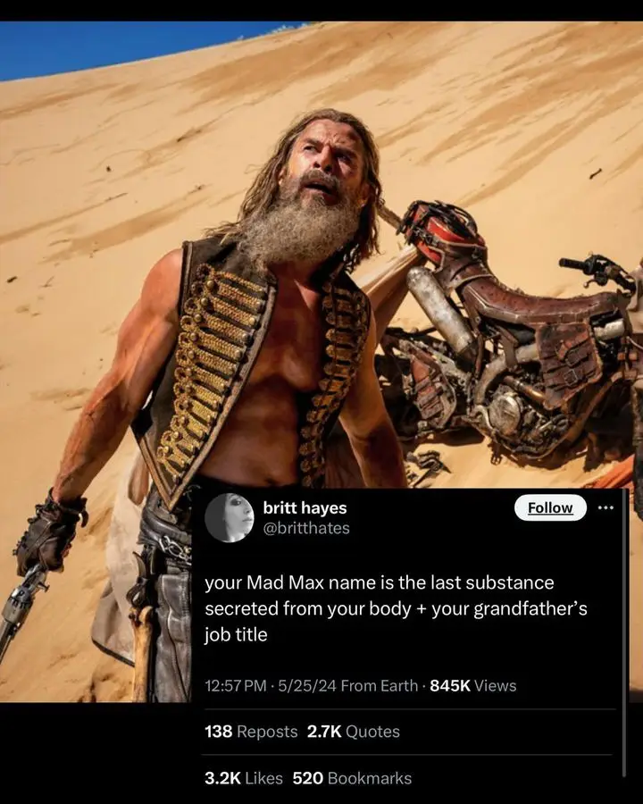 A muscular man with a long beard and a bullet belt stands in a desert next to a wrecked motorcycle. Overlaid is a screenshot…