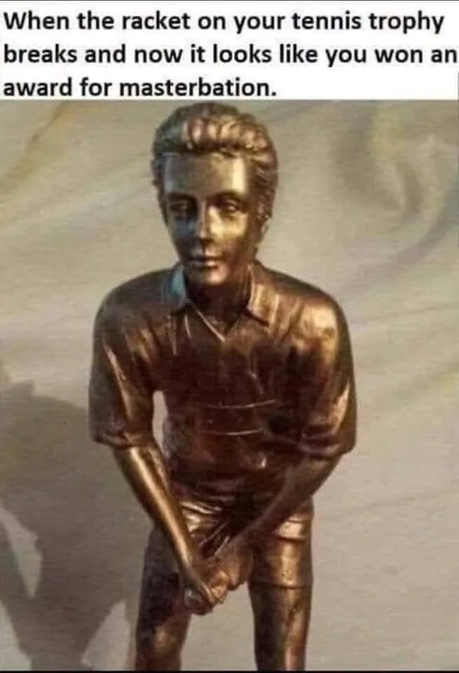 A bronze statue of a male tennis player in a shirt and shorts, holding a broken tennis racket in a way that resembles…