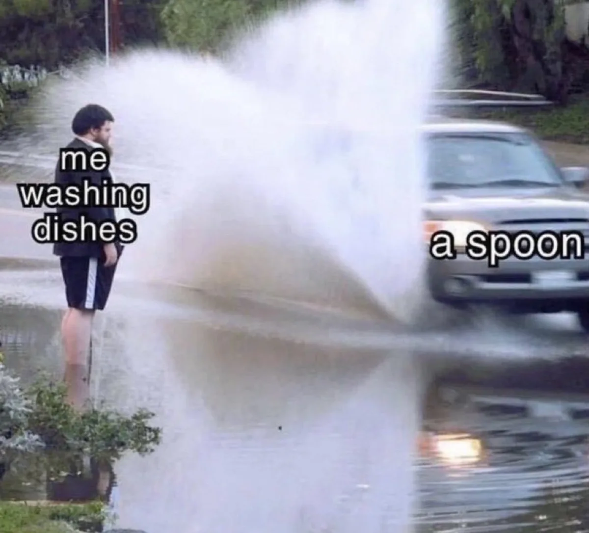 A man in a suit and shorts stands in a flooded street as a car drives by, spraying water in a huge arc. Text labels him 'me…