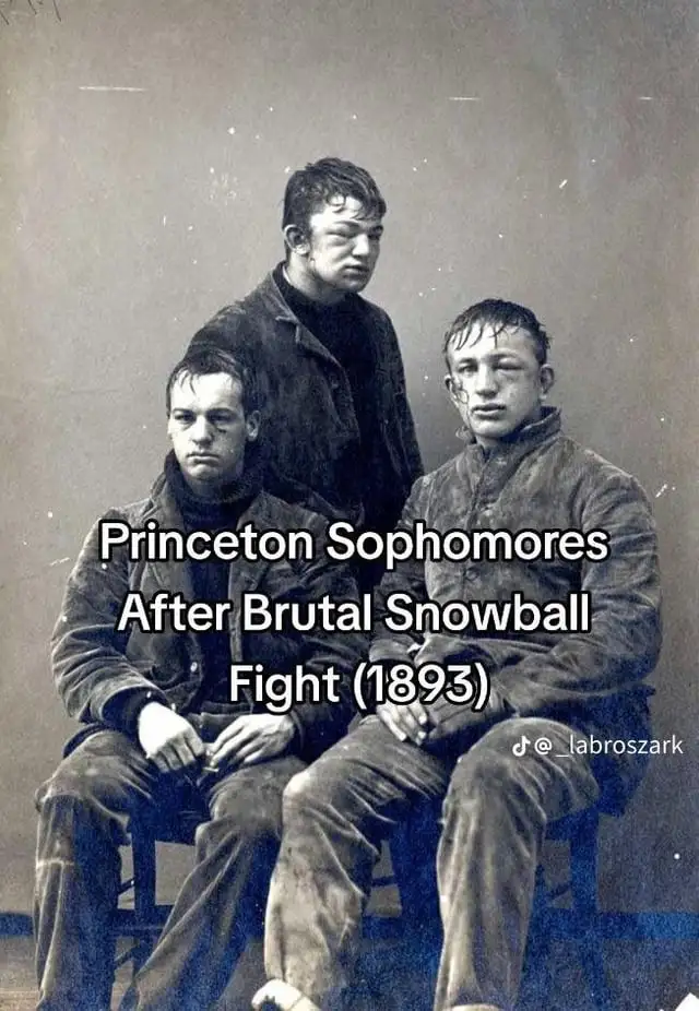 A sepia-toned, vintage photograph from 1893 shows three young men in heavy coats, visibly disheveled with snow on their hair…