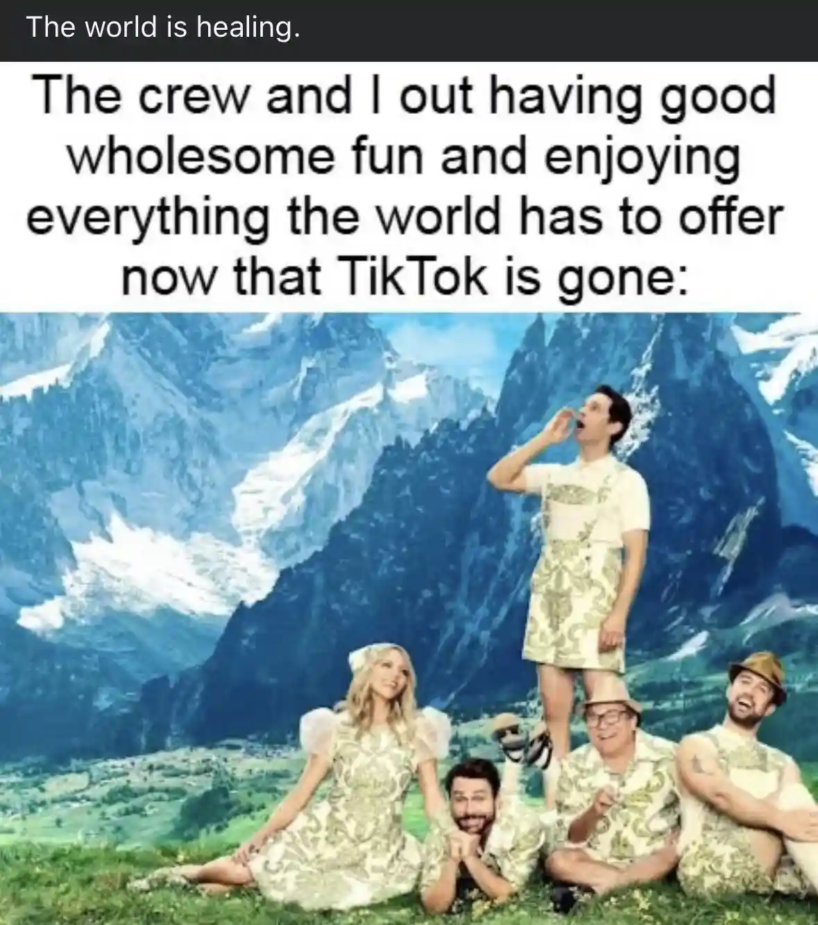 Five people in matching 1970s-style patterned outfits pose cheerfully in a scenic mountain valley. One man stands atop…