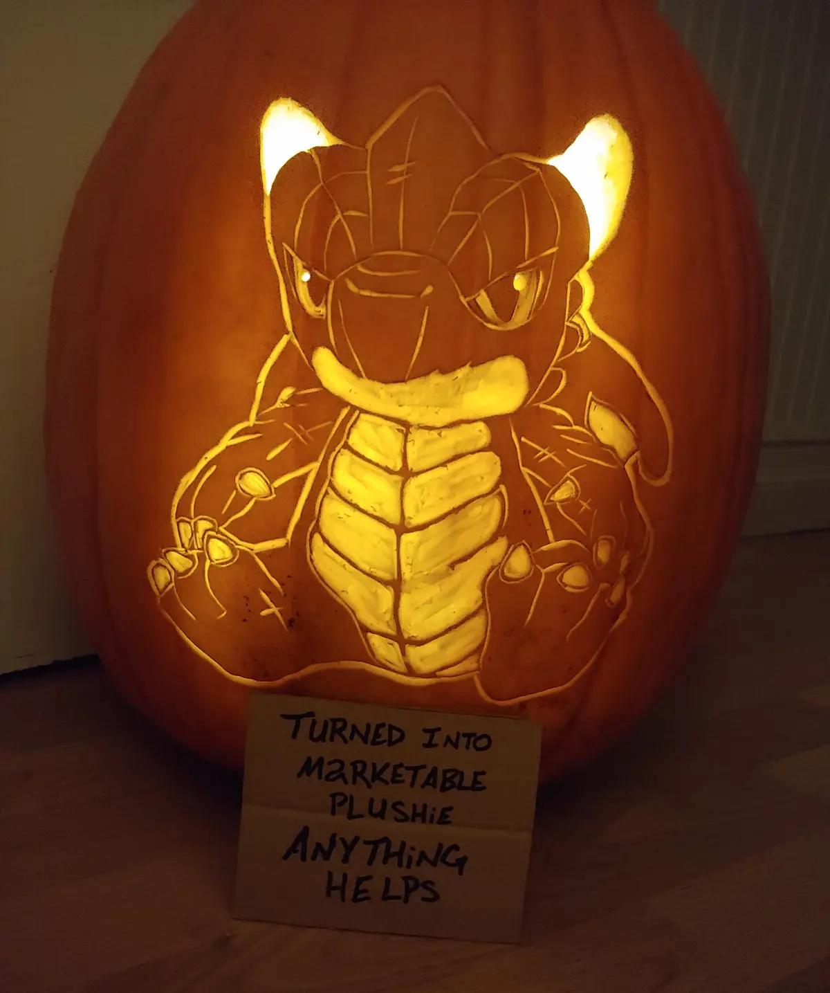 A carved Halloween pumpkin with an illuminated design of the Pokémon character Tyranitar, featuring its signature spiked…