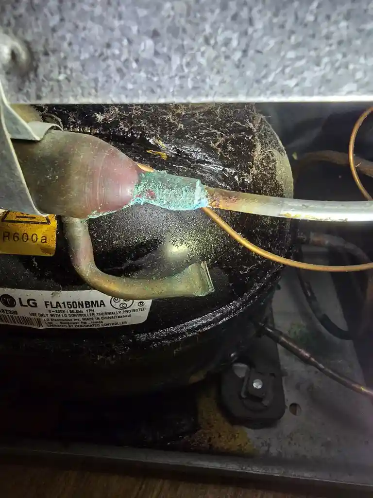 A close-up photo shows a heavily corroded and dirty copper refrigerant line connected to an LG air conditioner compressor…