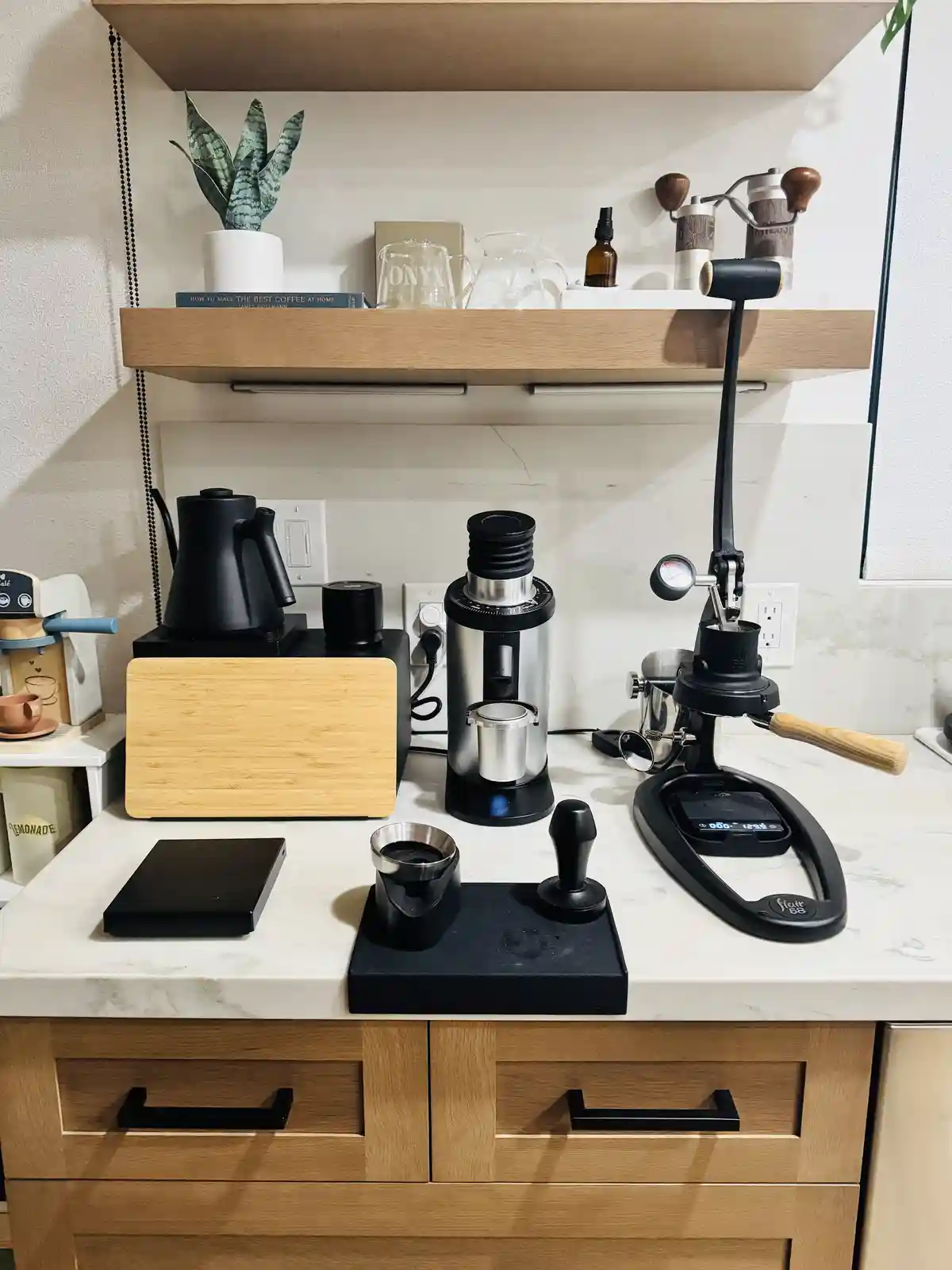 A well-organized home coffee station features a variety of high-end equipment including a burr grinder, a manual espresso…