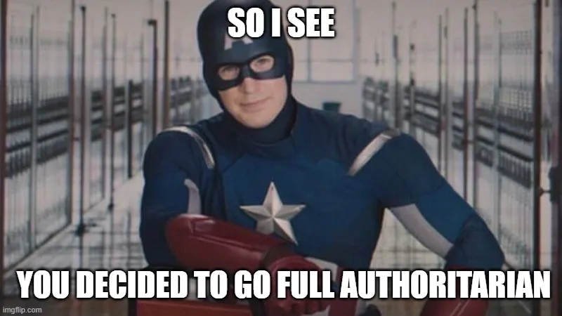 A man in a blue superhero costume with a star on his chest and red gloves stands in a prison corridor, looking smug. White…
